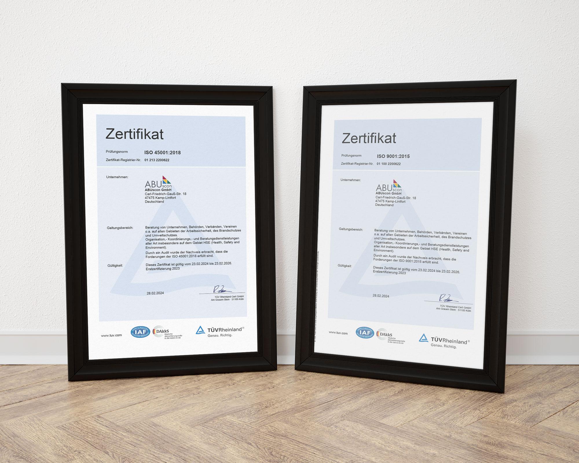 Ein roter Feuerlöscher ist an einer Wand befestigt. Der schwarze Schlauch und der silberne Griff sind deutlich sichtbar. Der Hintergrund besteht aus einer hellen, strukturierten Wand.